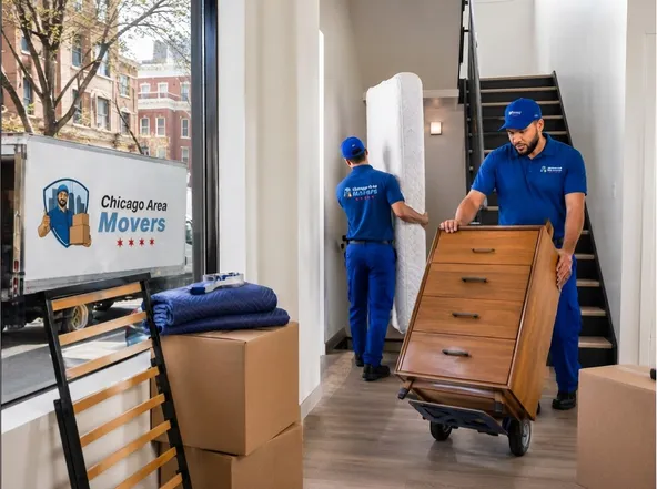 Movers carrying a wrapped piece of furniture out to the truck